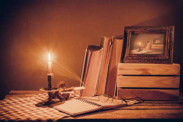 Письменный стол в свете горящей свечи