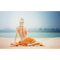 Девушка в оранжевом полотенце возле бассейна
