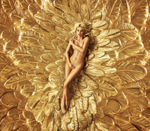 Дівчина лежить на золотих крилах