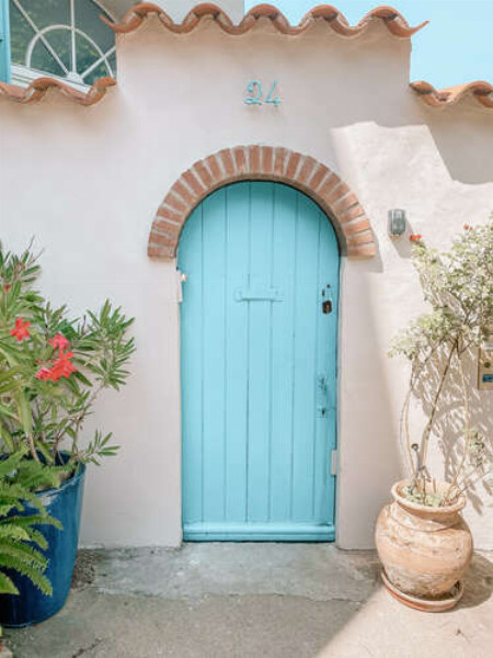 Голубая деревянная дверь дома с черепичной крышей