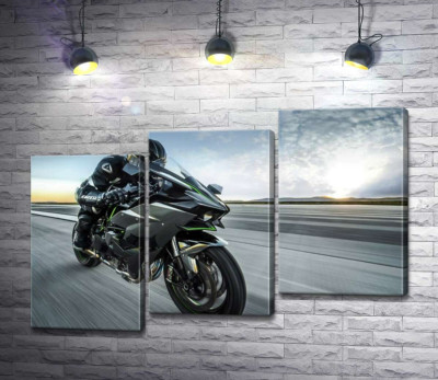 Гонщик мчить на чорному мотоциклі Kawasaki Ninja