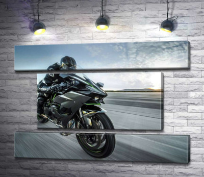 Гонщик мчит на черном мотоцикле Kawasaki Ninja