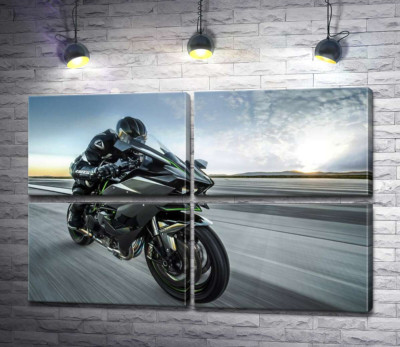 Гонщик мчит на черном мотоцикле Kawasaki Ninja