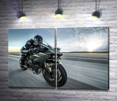 Гонщик мчить на чорному мотоциклі Kawasaki Ninja