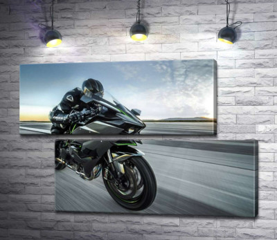 Гонщик мчит на черном мотоцикле Kawasaki Ninja
