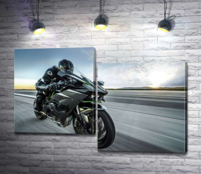 Гонщик мчит на черном мотоцикле Kawasaki Ninja