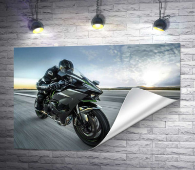 Гонщик мчить на чорному мотоциклі Kawasaki Ninja