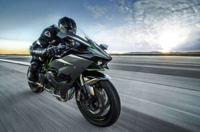 Гонщик мчить на чорному мотоциклі Kawasaki Ninja