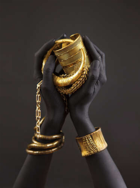 Темные руки с золотыми украшениями