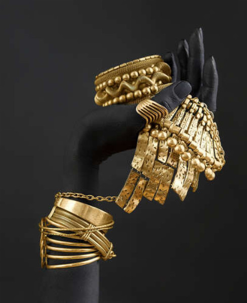 Темная рука с золотыми украшениями
