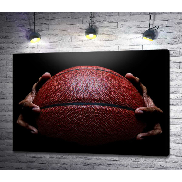 Баскетбольный мяч в руках спортсмена