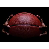 Баскетбольный мяч в руках спортсмена