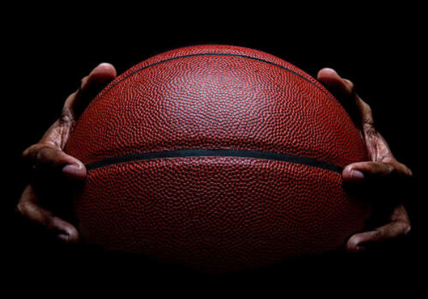 Баскетбольний м'яч у руках спортсмена