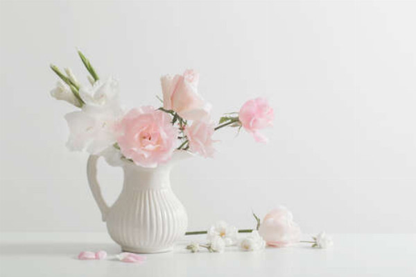 Ніжний букет троянд і гладіолусів у білому глечику