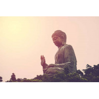 Огромная статуя Будды на фоне заходящего солнца