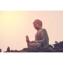 Огромная статуя Будды на фоне заходящего солнца