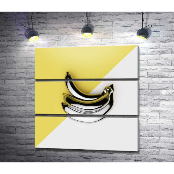 Металеві банани на жовто-білому тлі