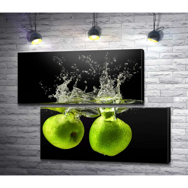 Два зелені яблука у воді