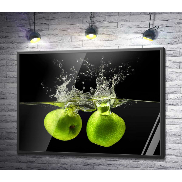 Два зелені яблука у воді