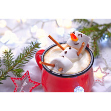 Веселий сніговик-маршмеллоу відпочиває у чашці різдвяного какао