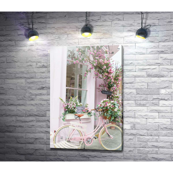 Рожевий велосипед біля затишного фасаду з квітами