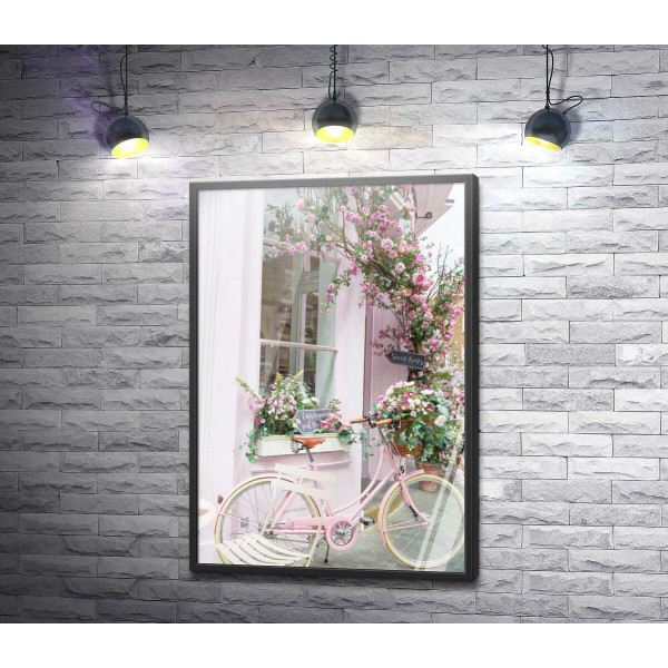 Розовый велосипед возле уютного фасада с цветами