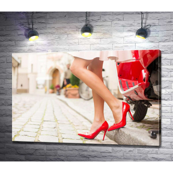 Дівчина в червоних туфлях на затишній вуличці