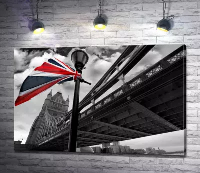Британский флаг висит на фонаре среди Тауэрского моста (Tower Bridge)