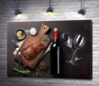 Красное вино в бутылке возле вкусного стейка