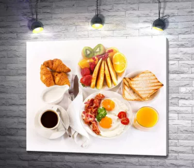 Сытный завтрак из яичницы, бекона, фруктов и выпечки