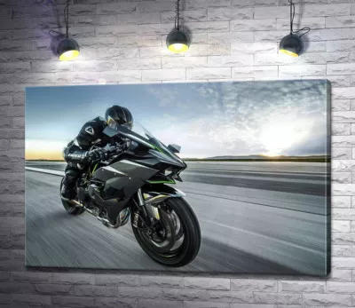 Гонщик мчит на черном мотоцикле Kawasaki Ninja