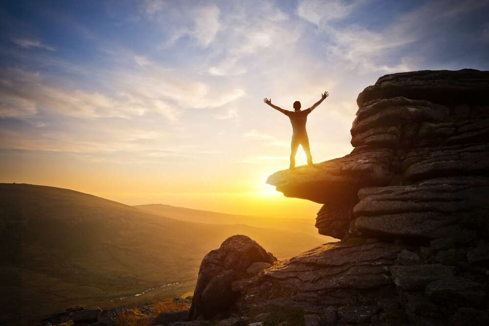 картина-постер Единение с природой: человек на вершине горы в солнечных лучах