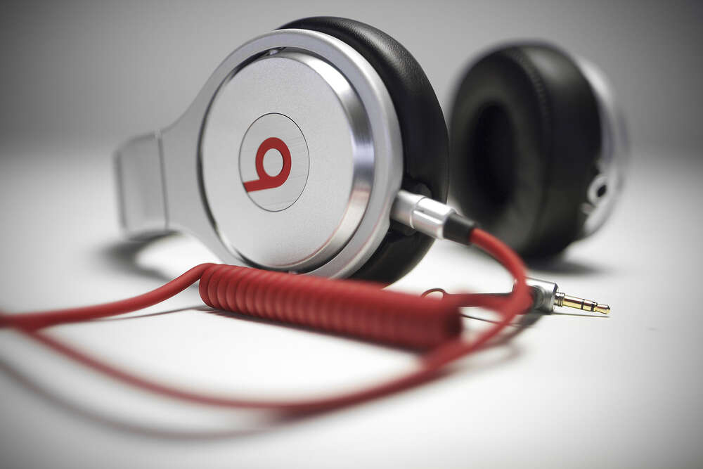 картина-постер Тонкі форми білого корпусу навушників Beats у поєднанні із завитками червоного провода