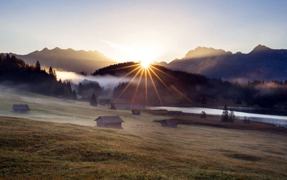 картина-постер Лучи солнца рассеивают утренний туман над горной долиной
