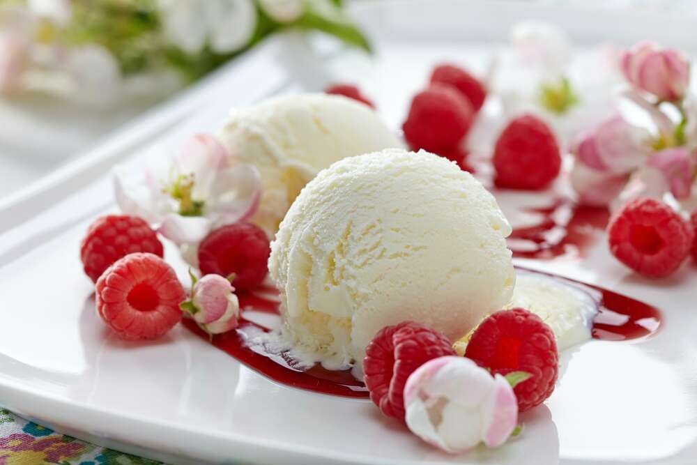 картина-постер Шарики ванильного мороженого на тарелке с ягодами малины и нежными цветами