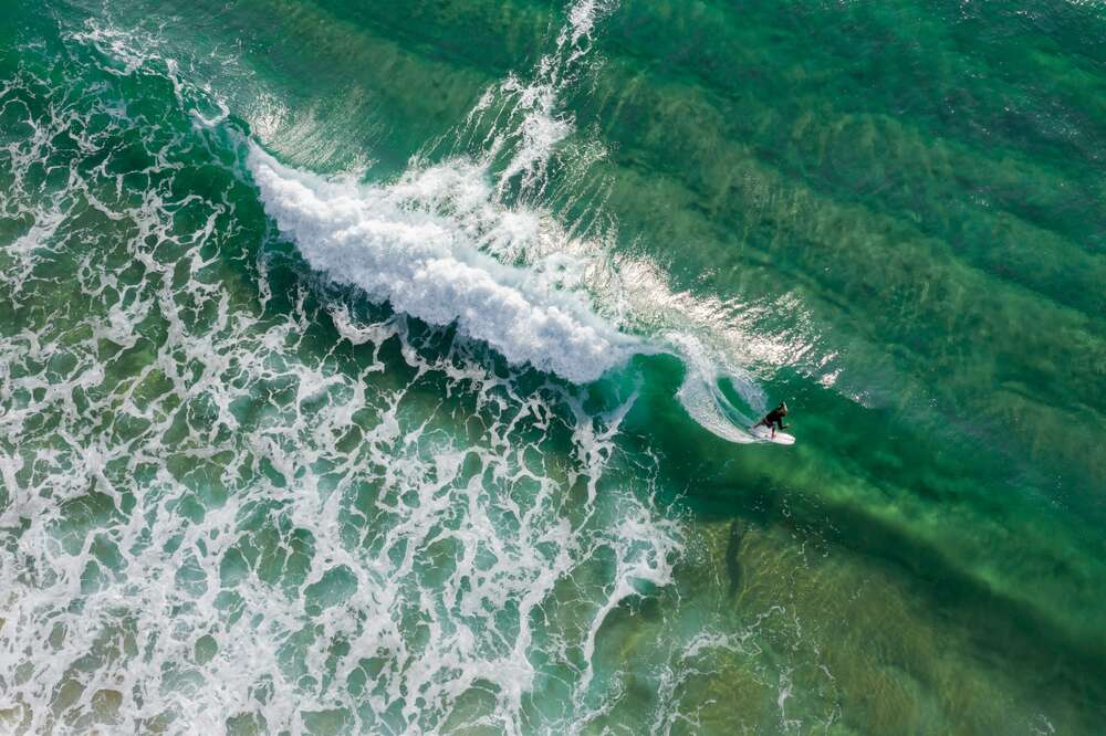 картина-постер Смелый серфингист выныривает из гребня волны