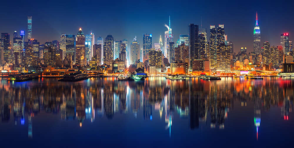 картина-постер Розмиті силуети хмарочосів Манхеттену (Manhattan) відбиваються у темних водах протоки Іст-рівер (East River)