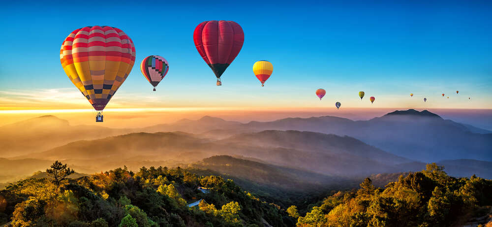картина-постер Ожерелье из воздушных шаров летит над туманными холмами в лучах утреннего солнца
