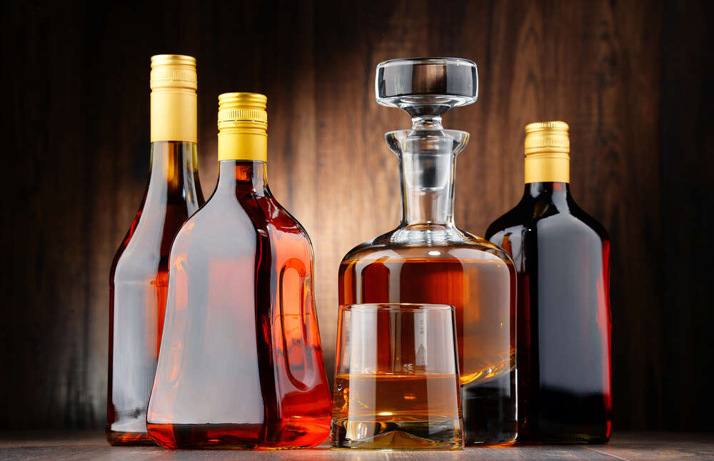картина-постер Медовые оттенки крепкого алкоголя в стеклянных бутылках