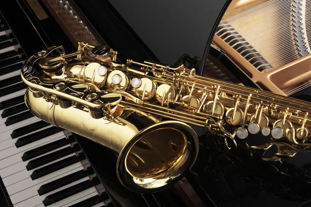 картина-постер Золотой силуэт саксофона контрастирует с черной поверхностью рояля