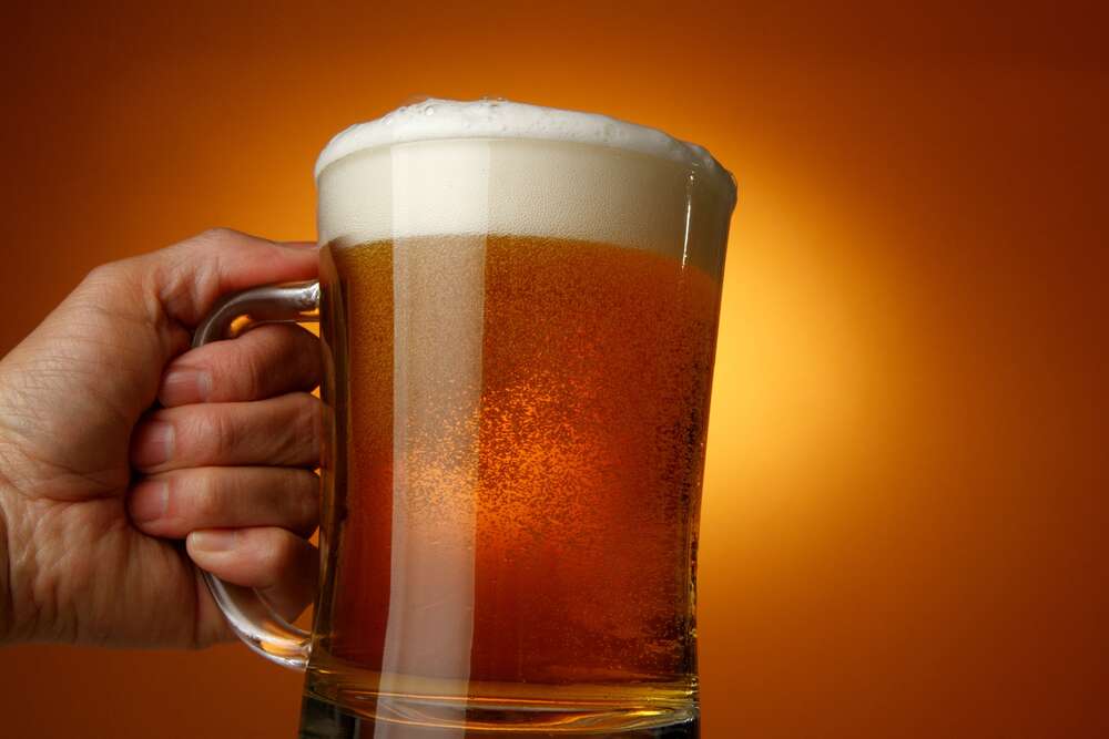 картина-постер Стеклянный бокал светлого пива в руке