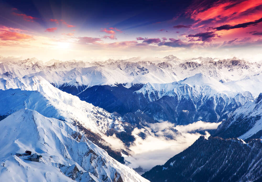 картина-постер Солнечные лучи падают на заснеженные вершины горных хребтов