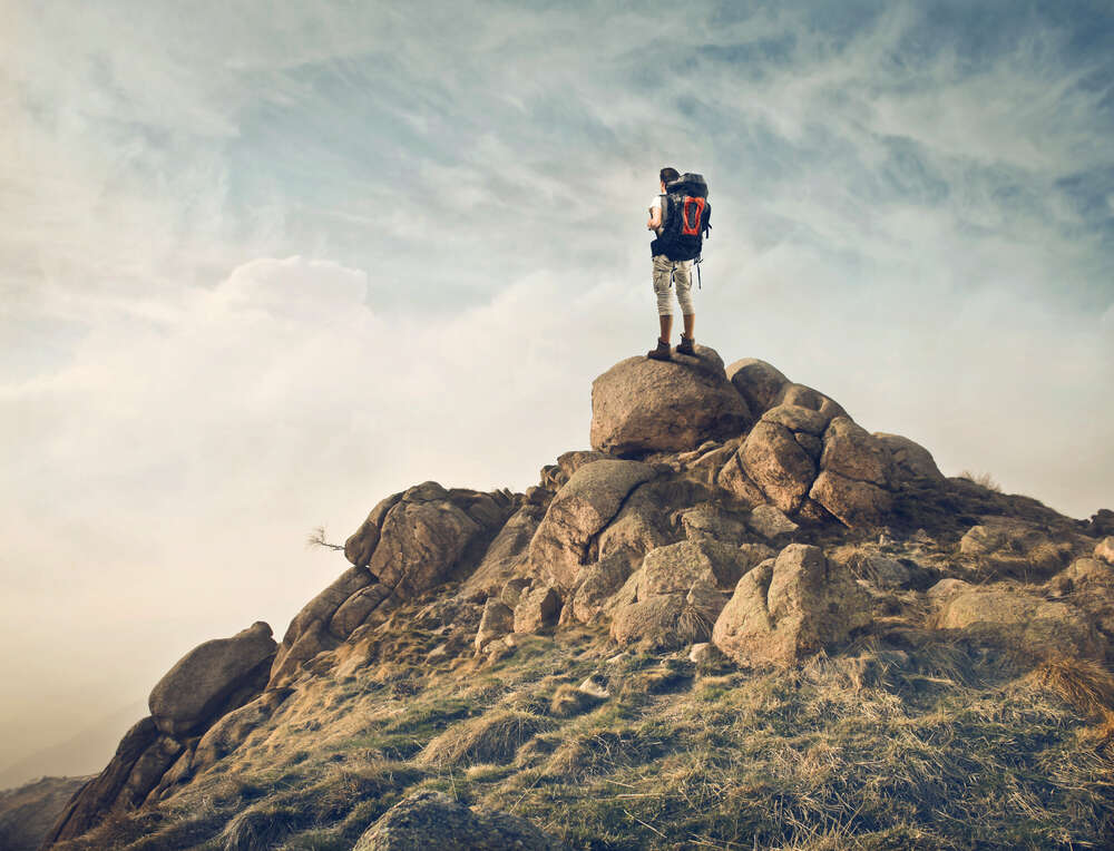 картина-постер Силуэт туриста на вершине каменной скалы