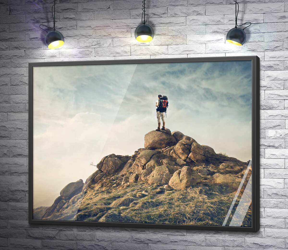 постер Силуэт туриста на вершине каменной скалы
