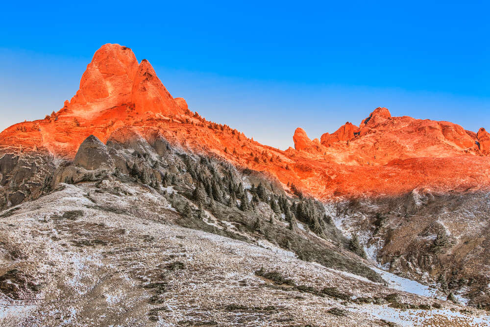 картина-постер Помаранчеве сонячне світло розтоплює сніг на вершинах гір