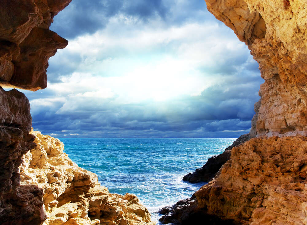 картина-постер Природная арка между скалами ведет к морскому берегу