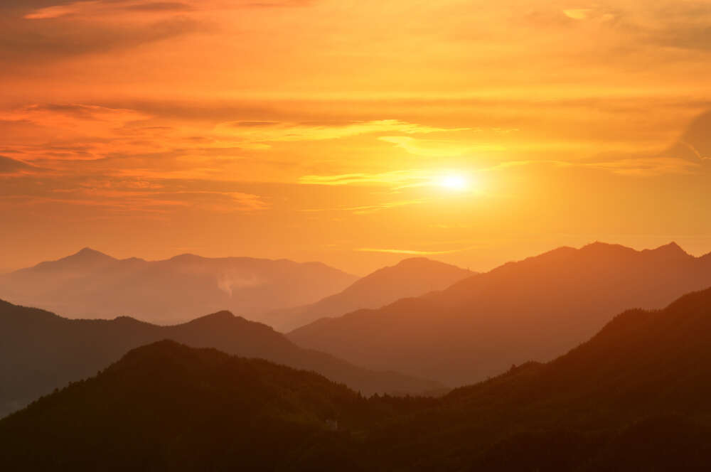 картина-постер Силуети гір у помаранчевих променях вечірнього сонця