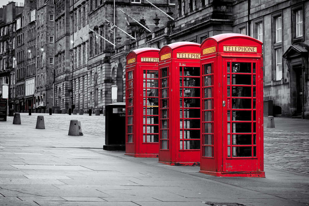 картина-постер Красные телефонные будки выстроились на тротуаре столичной улицы