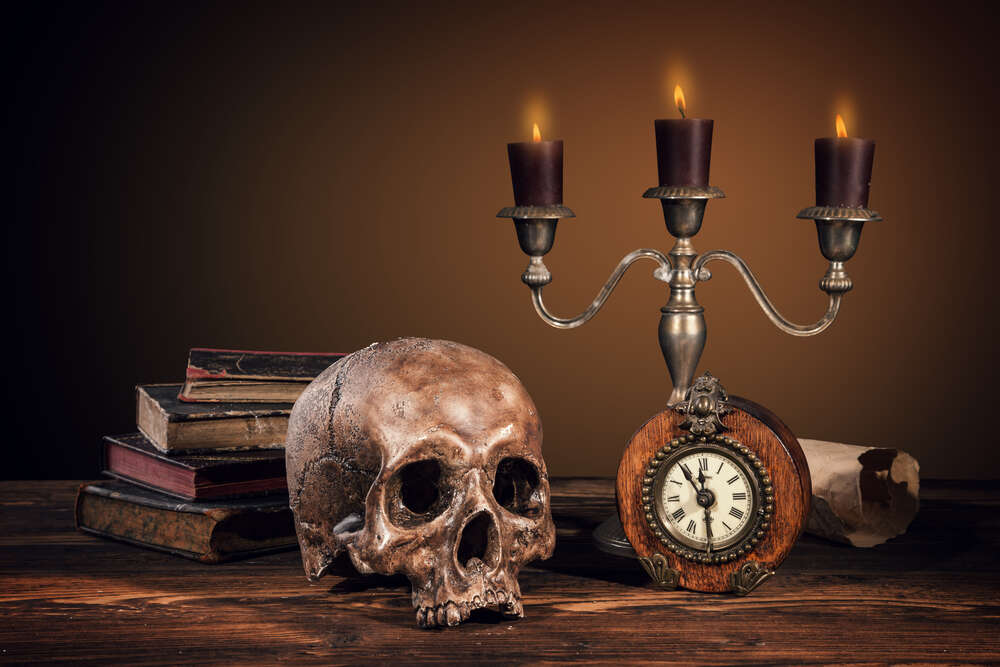 картина-постер Людський череп серед книг та свічок