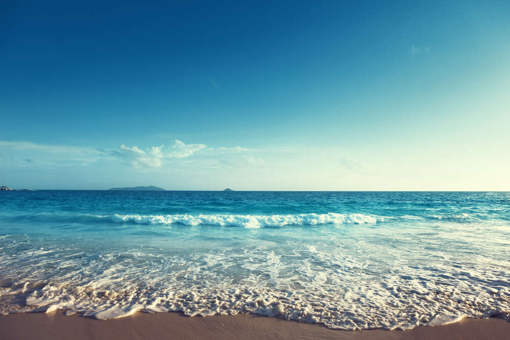 картина-постер Белая морская пена покрывает песчаный берег